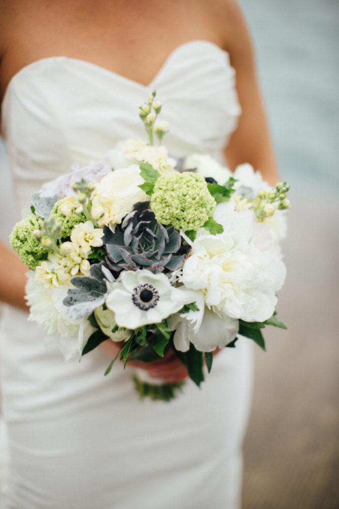 Spring bridal bouquet of snowball viburnum, pale yellow stock, white peonies and anemones, succulents, and dusty miller. 