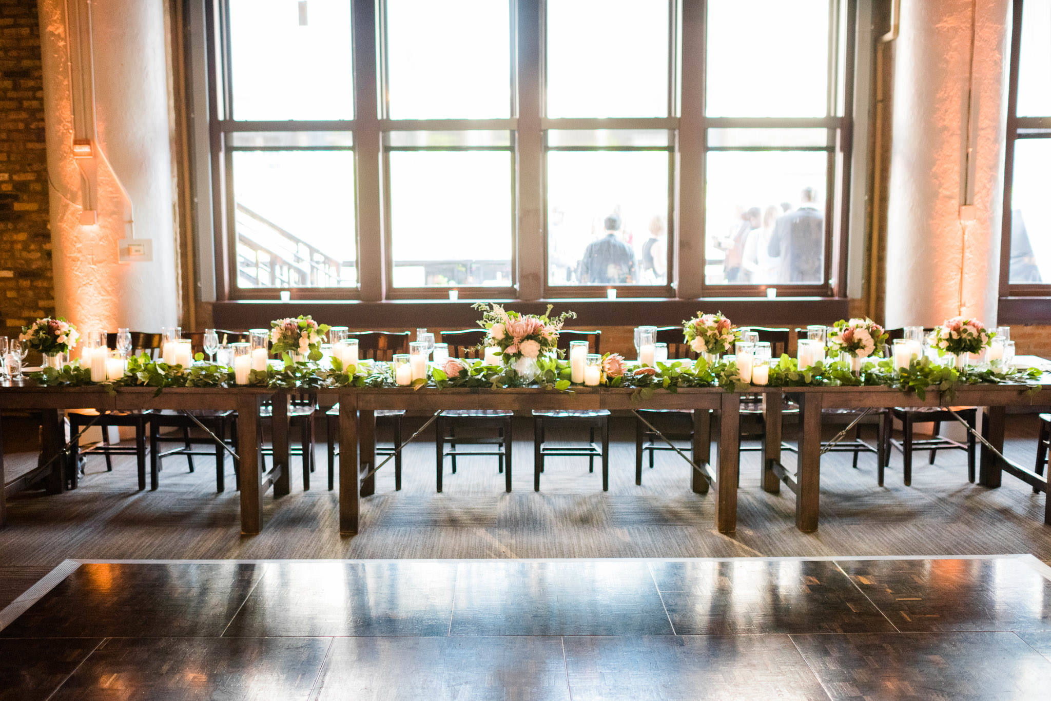 Wedding head table with garland and candles at River Roast in Chicago.
