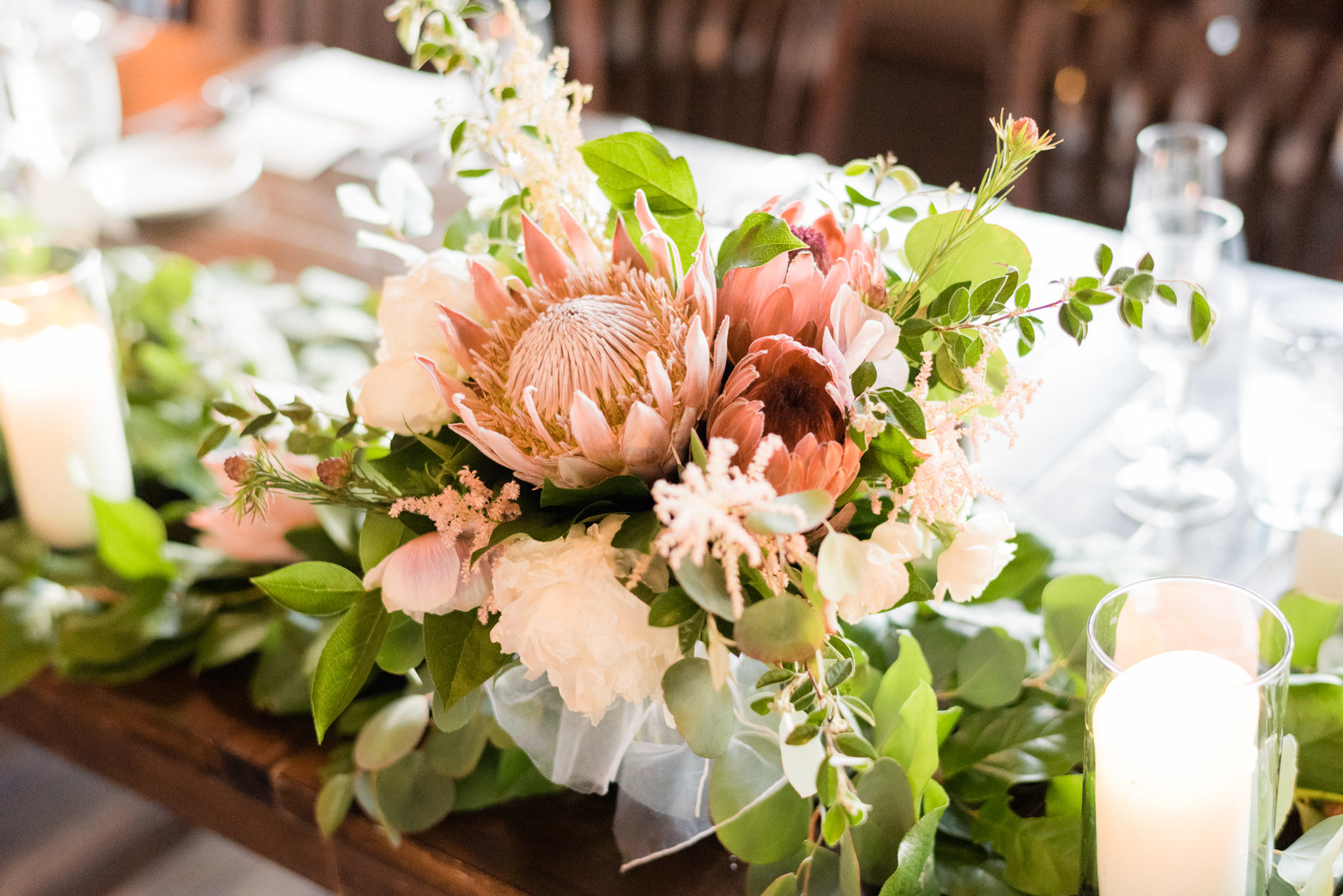 Spring bride's bouquet with blush protea, white anemone, pale pink astilbe, and ivory peonies.