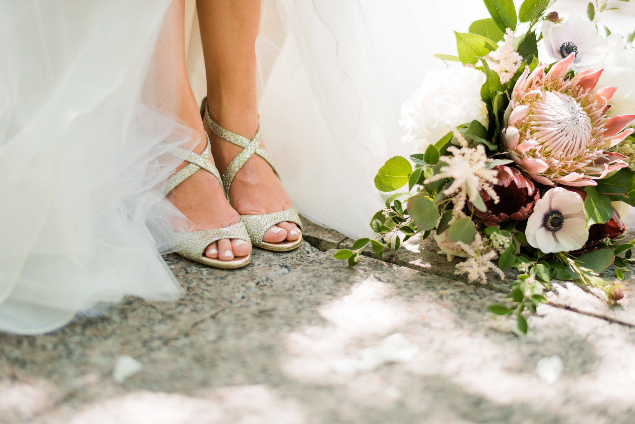 Detail shot of bride's silver shoes and bouquet.