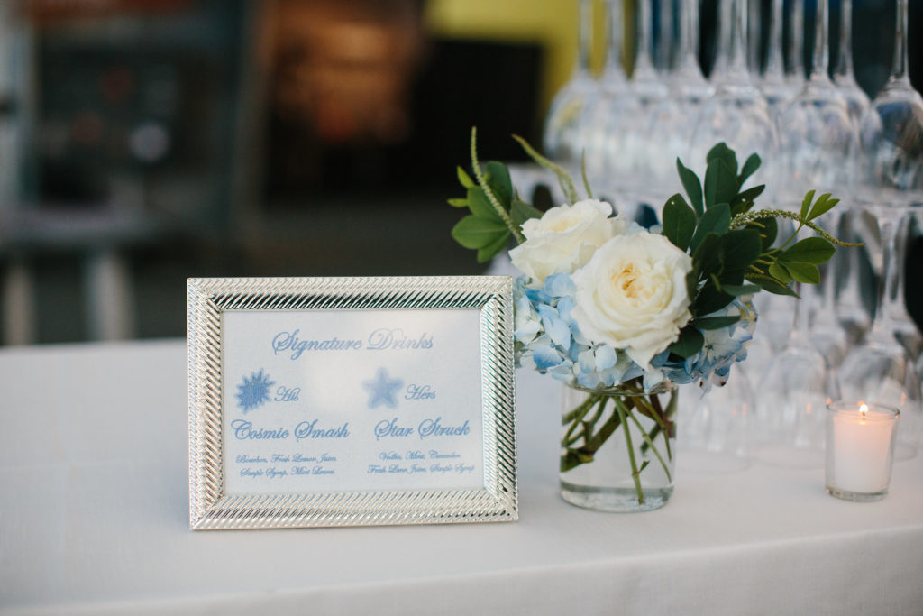 Drink table with simple arrangement of ivory garden roses and blue hydrangea at Adler Planetarium for summer wedding. 