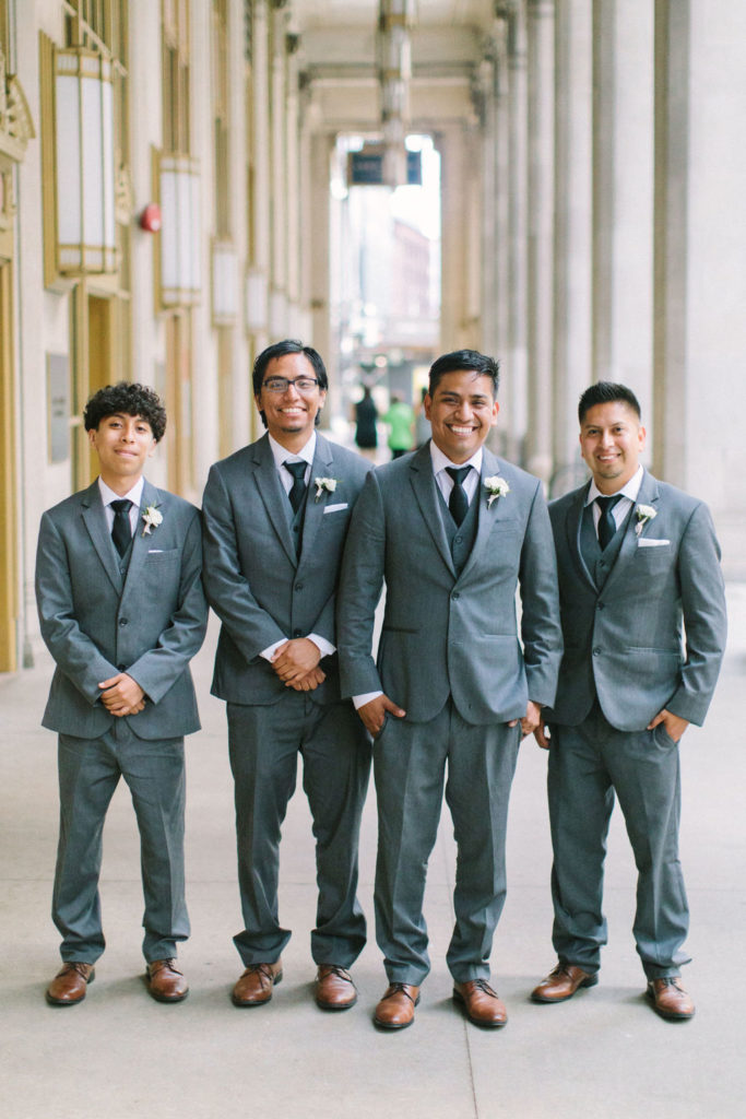 Groom and groomsmen with ivory boutonnieres for outdoor summer wedding.