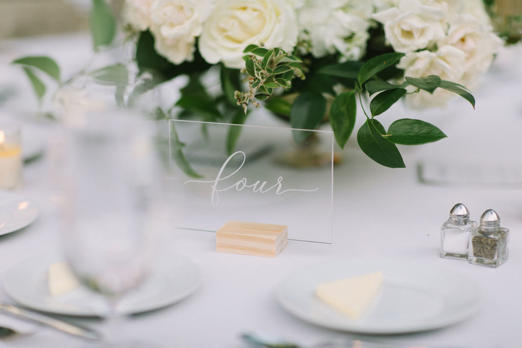 Acrylic table markers for a simple and sophisticated outdoor wedding reception in Chicago with garden inspired bouquets of ivory garden roses, pale pink peonies, and flowering branches.