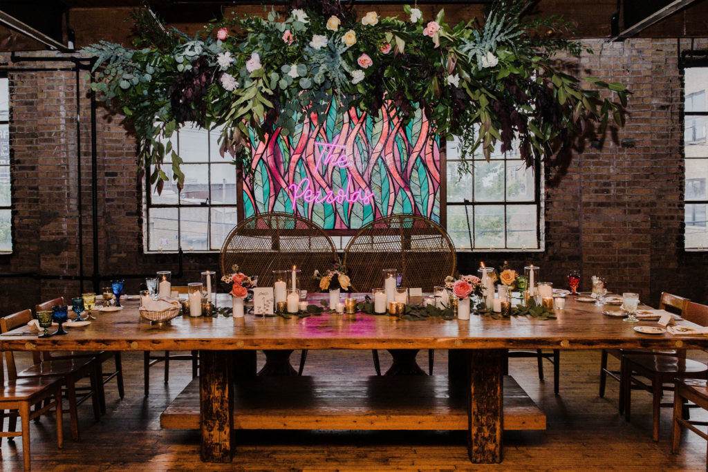 Bohemian wedding head table with lush hanging floral installation of eucalyptus, ferns, garden roses at Salvage One in Chicago. 