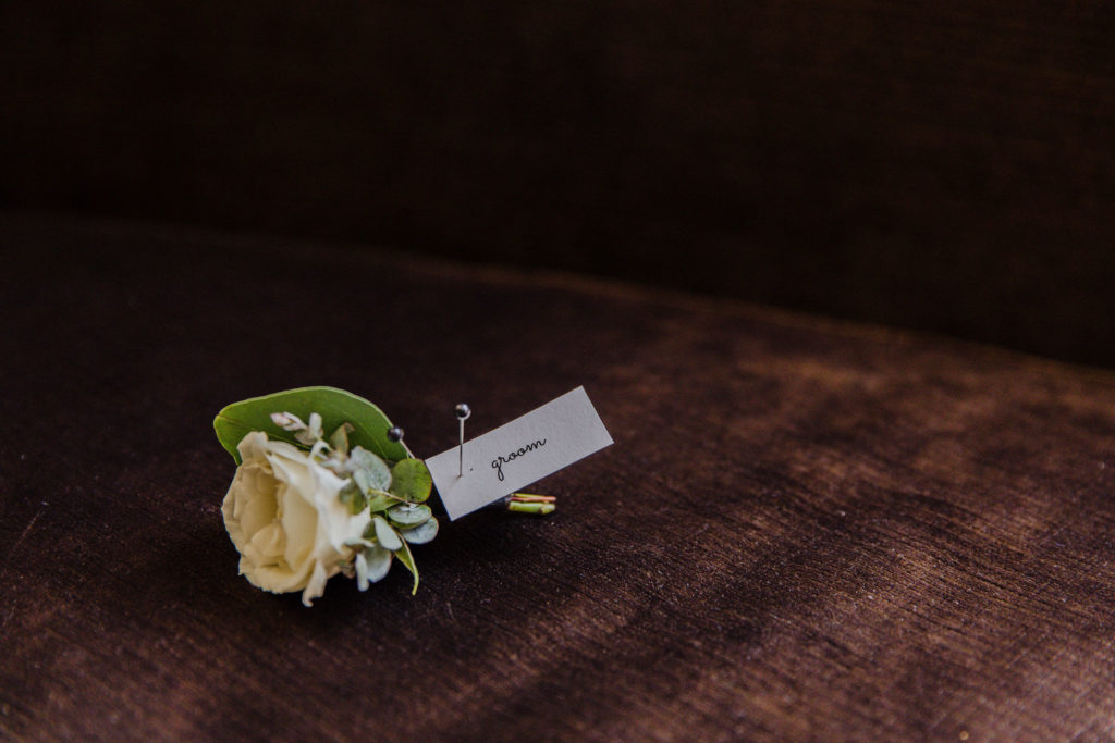 Delicate groom’s bout with an ivory spray rose and sage green foliage for a Salvage One wedding in Chicago.