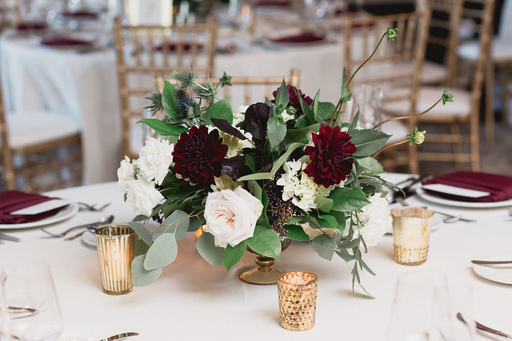 Taller buds added understated whimsy, while burgundy dahlias added depth to the arrangements at the reception tables. 