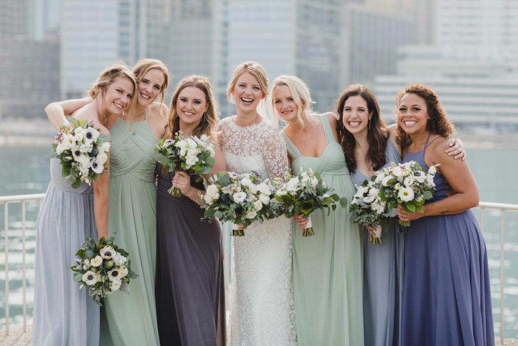 Bride and bridesmaids in a palette of sage green, periwinkle, dusty blue, and charcoal. Monochromatic bouquets were of anemones, spray roses, berries, thistle, dusty miller, and eucalyptus.