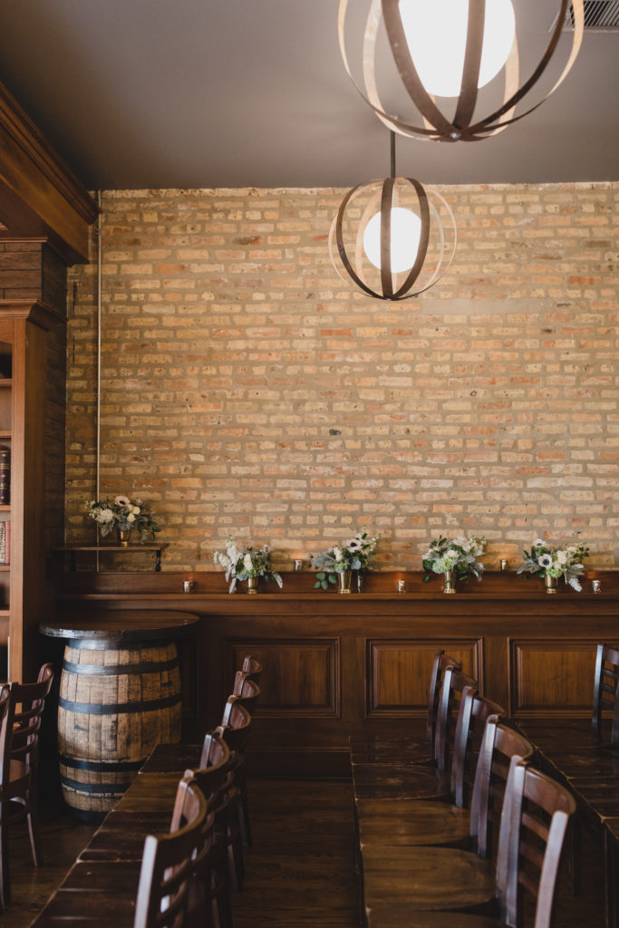 Arrangements lined the wall at this Revolution Brewing wedding ceremony, which included flowers of anemones, stock, hydrangea, thistle, eucalyptus, and dusty miller. 