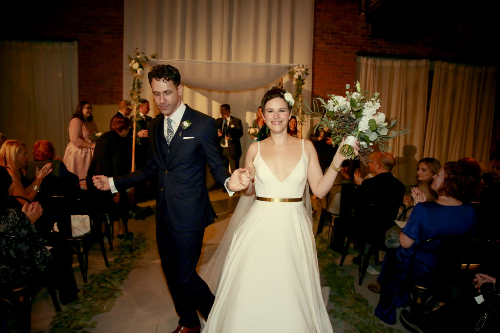 Bride and groom walking down the aisle and dancing at their romantic fall wedding at Artifact Events in Chicago.