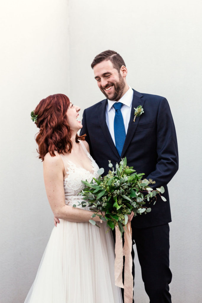 Bride and groom portrait for a winter wedding at Floating World Gallery in Chicago, with an elegant foliage bouquet of eucalyptus with a blush silk ribbon. 