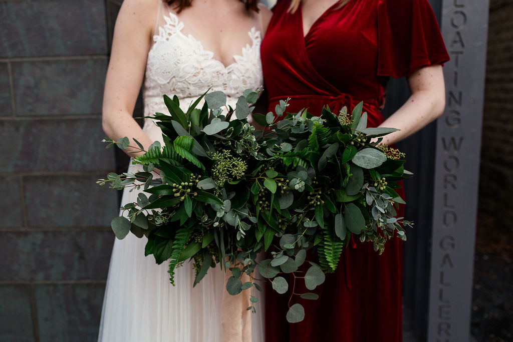 Elegant foliage bouquets of fern, silver dollar eucalyptus and seeded eucalyptus for a winter wedding at Floating Gallery Chicago, with the bride's bouquet wrapped with a blush silk ribbon.