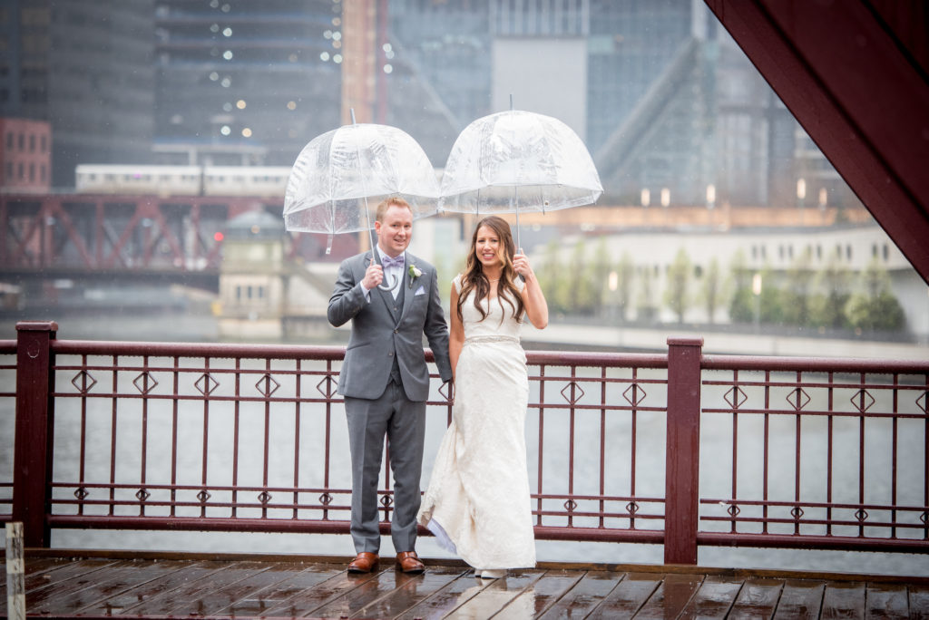 Chicago bride and groom under umbrellas in the spring rain.