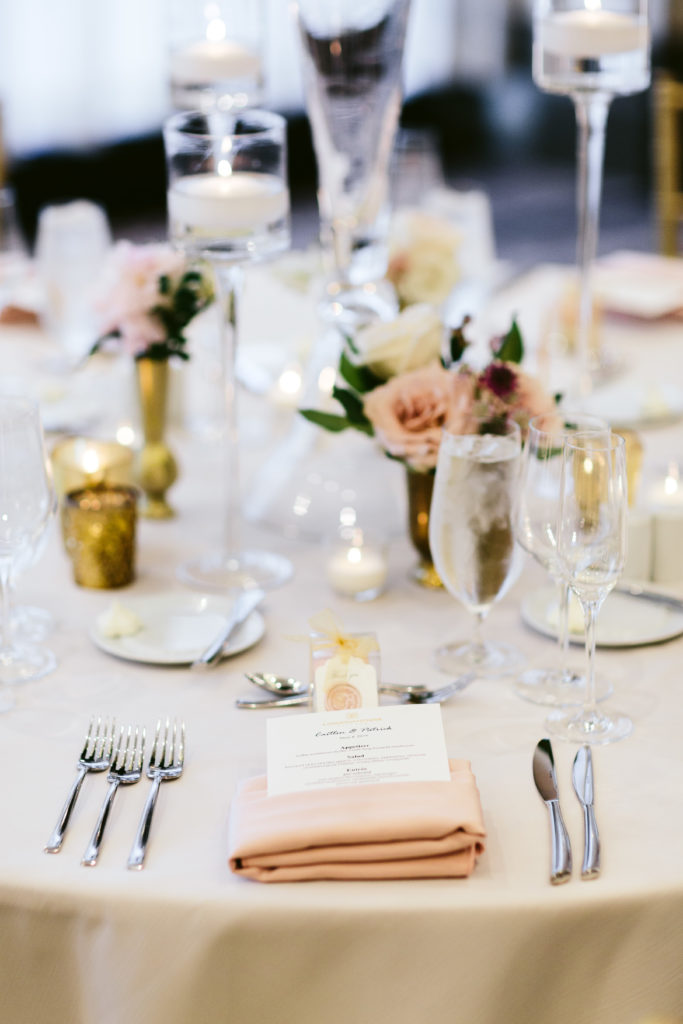 Low, mini table arrangements in brass vases with blush and ivory garden roses.