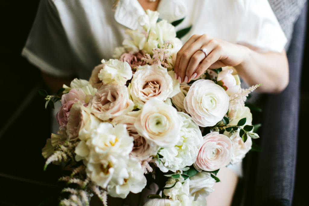 Classic bridal bouquet in ivory and blush with peonies, ranunculus, garden roses, and astilbe. 