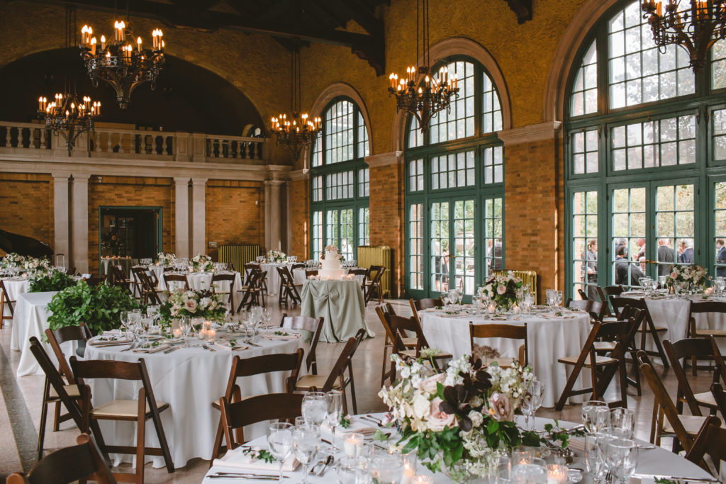 Late summer outdoor wedding reception in Chicago at Columbus Park Refectory with blush, mauve, and ivory centerpieces of tardiva hydrangea, Japanese anemone, and scabiosa. 