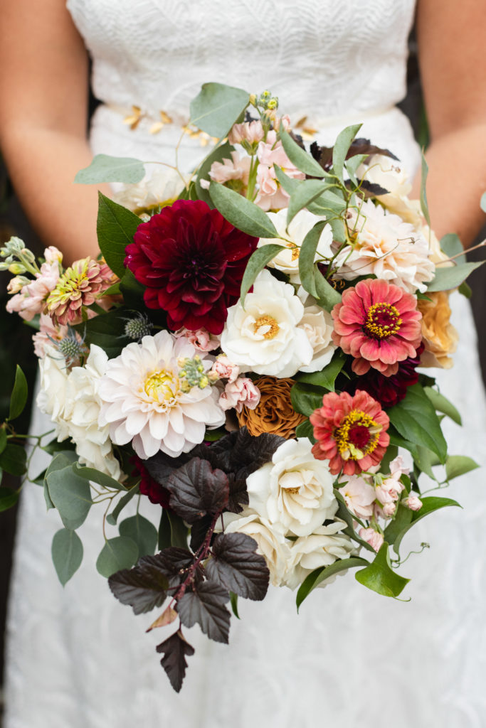 Late summer/early fall bridal bouquet of garden roses, blush and burgundy dahlias, pink zinnias, ivory majolica roses, eucalyptus, and stock.