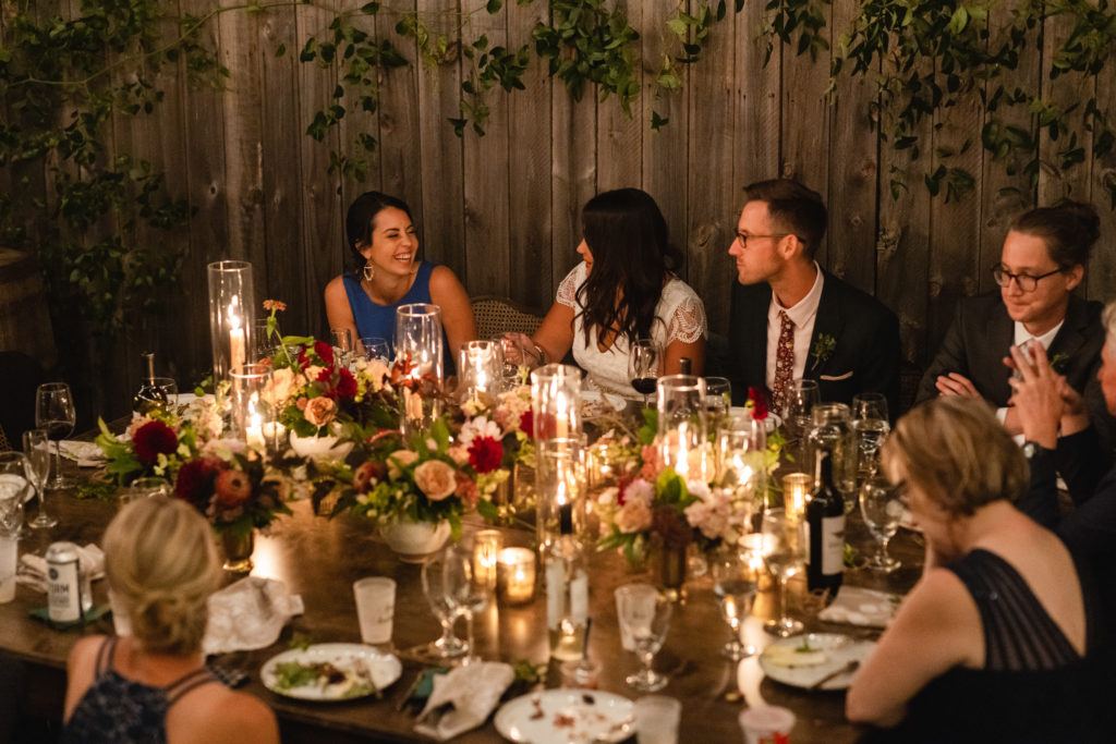 Enjoying dinner, provided by Cafe Lula, near the end of this rustic September backyard micro wedding in Chicago.